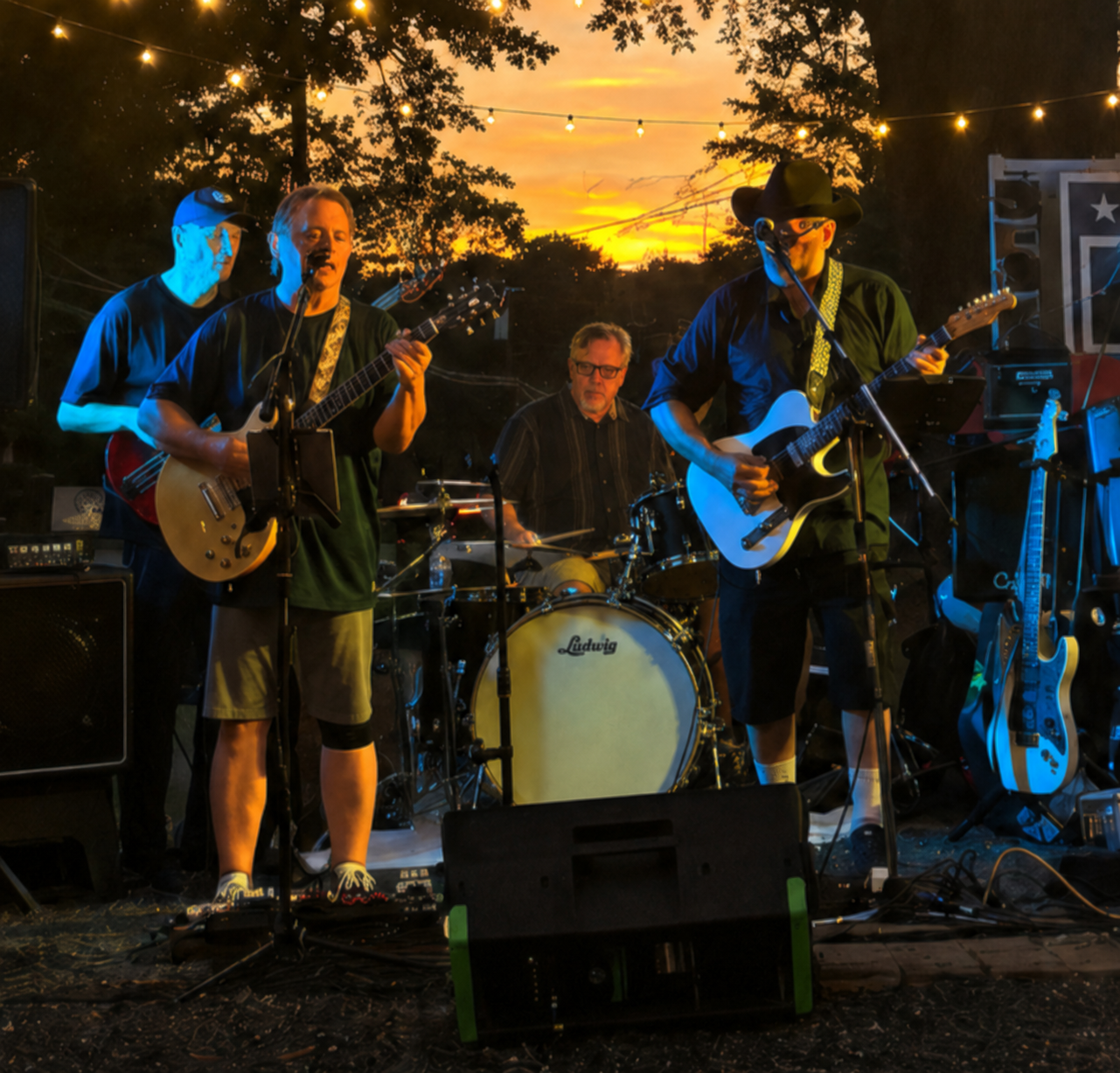 Big Creek Country Band performing onstage at sunset under string lights